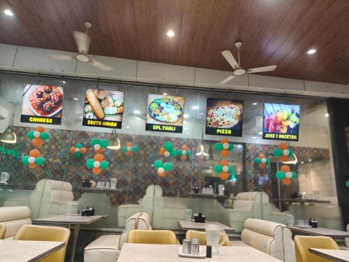 a restaurant with tables and chairs and signs on the wall at Hotel Shirdi Park Inn 80 Meters From Sai Samadhi Temple in Shirdi