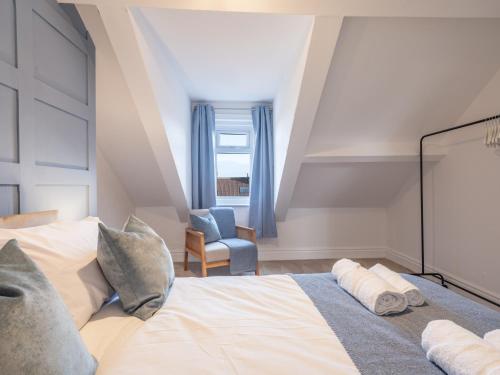 um quarto com uma cama grande e uma cadeira em Cosy Coastal Apartment em Whitley Bay