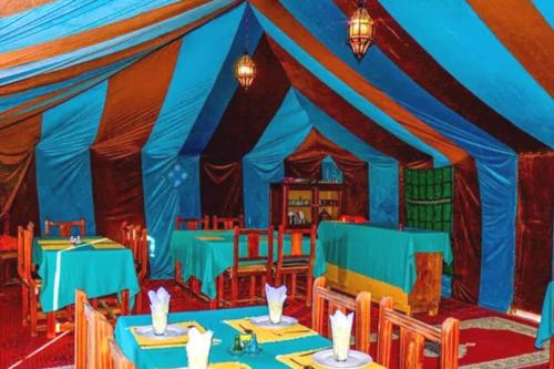 a painting of a dining room with blue tables at Overnight Camp Erg Chebbi in Merzouga