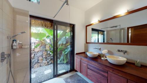 a bathroom with two sinks and a shower at Villa Balinaise avec piscine in Rivière Noire