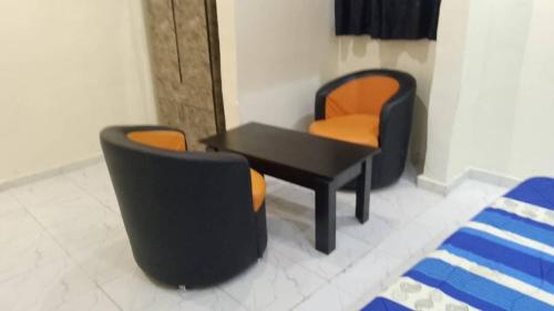 JEFFOSA Hotel & Suites في لاغوس: غرفة بها كرسيين وطاولة وكرسيين