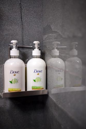 a group of four bottles of soap on a shelf at Revive Boutique Hotel in Yerevan
