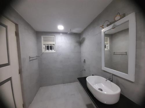 a white bathroom with a sink and a mirror at Villa one in Balapitiya