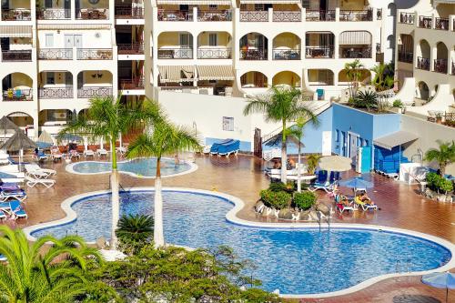 una vista aérea de una piscina del hotel con palmeras en Two-Floor Penthouse w/ Spa Tub & Outdoor Terrace, en Arona