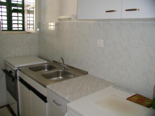 a small kitchen with a sink and a counter at Villa BORIĆ DARKO in Podgora