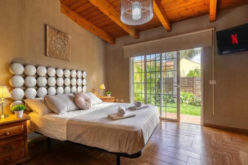 ein Schlafzimmer mit einem großen Bett und einem großen Fenster in der Unterkunft Garden Paradise House w/ BBQ & Volcano View in Icod de los Vinos