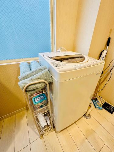a washing machine sitting in a corner of a room at Yokohama Paradise202 in Yokohama