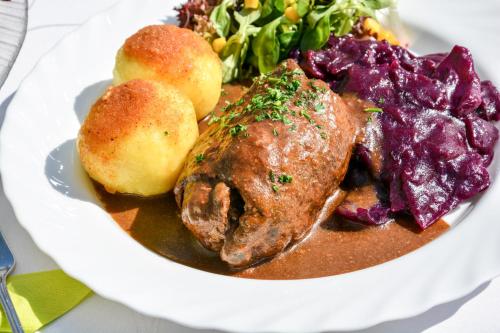 un piatto di alimenti con carne e verdure su un tavolo di Hotel zur Insel a Werder