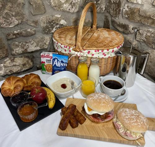 - une table avec des aliments pour le petit-déjeuner, du café et du jus d'orange dans l'établissement Horsemanstone, à Amroth