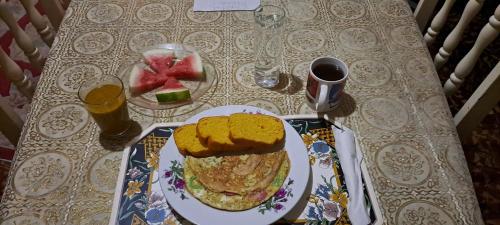 a table with a plate of food and a plate of fruit at Kingston Airport bed and breakfast in Kingston