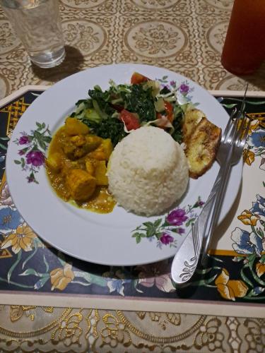 a plate of food with rice and vegetables on a table at Kingston Airport bed and breakfast in Kingston