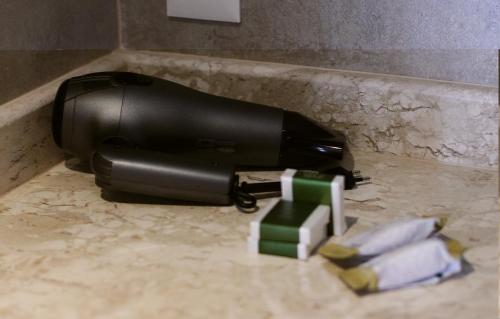 a black soap dispenser on a counter with towels at Buona Vitta Gramado Resort & Spa by Gramado Parks in Gramado