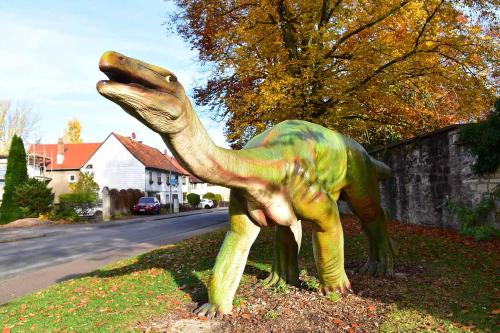 a statue of a dinosaur on the side of a street at Ferienwohnung Schlothauer 1 in Ruhla