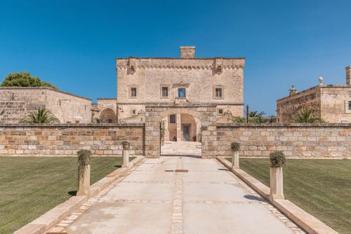 an old stone building with a walkway in front at Masseria Torrelonga in Fasano