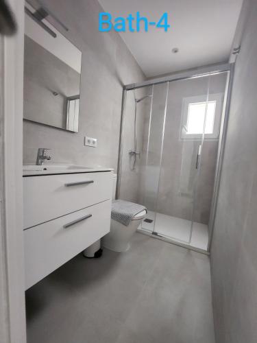 a white bathroom with a shower and a toilet at Villa Blue Lagoon Moraira in Moraira