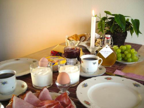 una tavola con uova, tazze e piatti di alimenti di Ferienwohnung in Preußisch Oldendorf a Preußisch Oldendorf