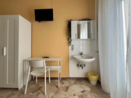 bagno con lavandino, tavolo e specchio di Hotel Parini a Cesano Boscone