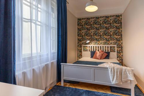 a small bedroom with a bed and a window at BB Görgey Apartman I. in Miskolc