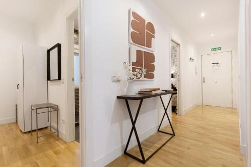 a hallway with a table in a room with white walls at Genteel Home Retiro in Madrid