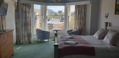 a bedroom with a bed and a large window at George and Abbotsford in Melrose