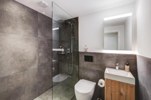 uma casa de banho com um chuveiro, um WC e um lavatório. em Bijou Lake Side - mit Seesicht und Privatstrand em Faulensee