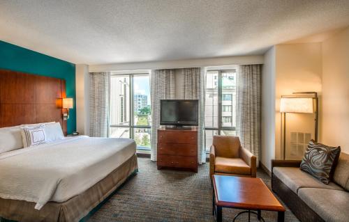 a bedroom with a bed and a tv and a couch at Residence Inn Arlington Courthouse in Arlington