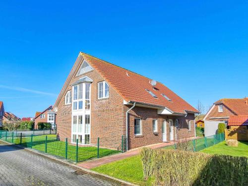 a brick house with a red roof on a street at Abendrot in Greetsiel