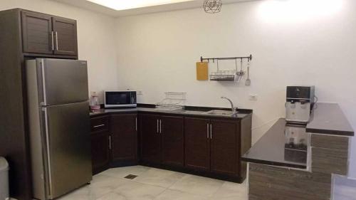 a kitchen with a stainless steel refrigerator and brown cabinets at Aroma Mountain Dead Sea in Sowayma