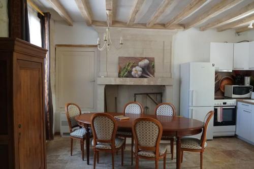 uma cozinha com uma mesa de jantar e cadeiras em Gîte Aliénor en Anjou em Vernoil
