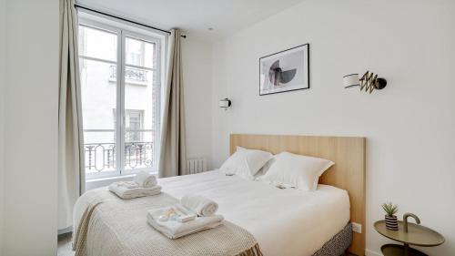 a bedroom with a bed with two towels on it at 154 Suite Phil - Superb apartment in Paris in Paris