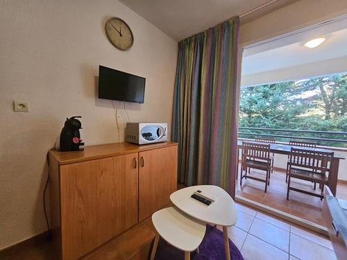 a room with a table and a clock on the wall at Casa Johanna, plage et piscine in Moriani Plage