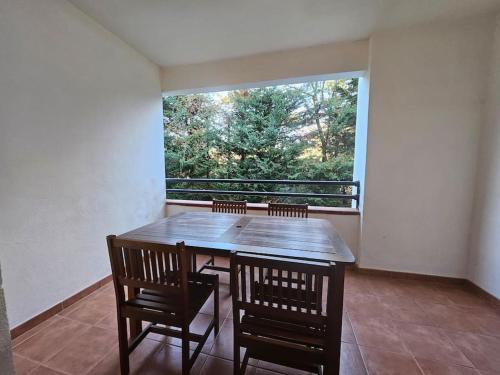 a dining room with a table and chairs and a window at Casa Johanna, plage et piscine in Moriani Plage