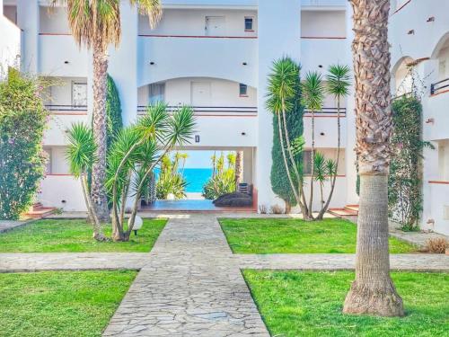 a courtyard with palm trees in front of a building at Casa Johanna, plage et piscine in Moriani Plage