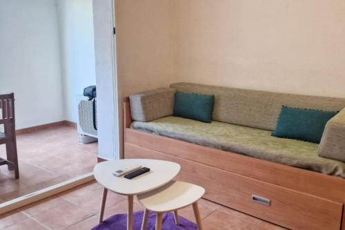 a living room with a couch and a table at Casa Johanna, plage et piscine in Moriani Plage