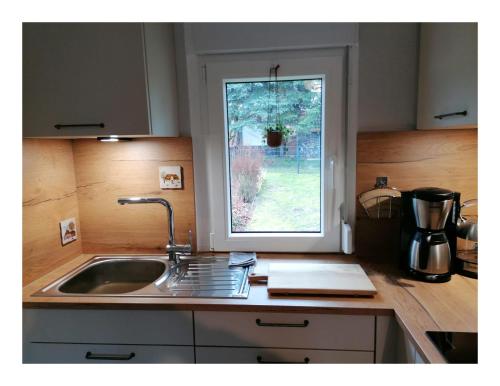 eine Küchentheke mit einem Waschbecken und einem Fenster in der Unterkunft Ferienhaus Fuxbau in Wohlau