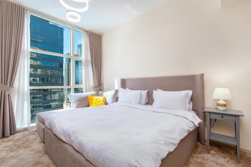 a bedroom with a large bed with a large window at Dubai Marina Next to Metro and JBR Beach - CityApartmentStay in Dubai