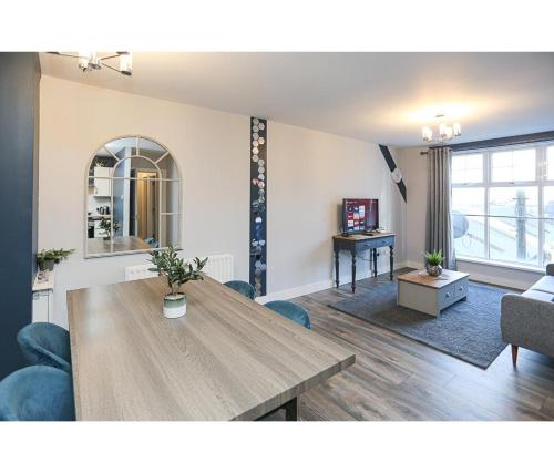 a living room with a wooden table and blue chairs at Central Belfast Apartments Alfred Street in Belfast