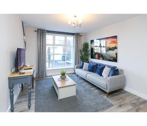 ein Wohnzimmer mit Couch und Schreibtisch in der Unterkunft Central Belfast Apartments Alfred Street in Belfast