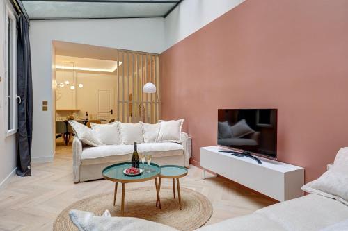 un salon avec un canapé et une télévision dans l'établissement 305 Suite Lion - Superb apartment in Paris, à Paris