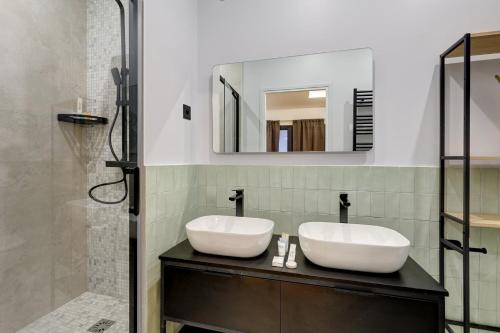 une salle de bain avec deux lavabos et un miroir dans l'établissement 305 Suite Lion - Superb apartment in Paris, à Paris