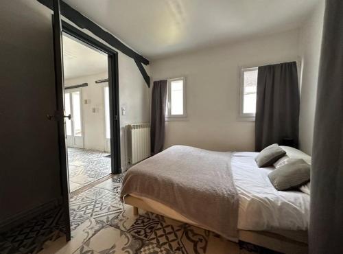 - une chambre avec un lit et un grand miroir dans l'établissement Le Vintage- bords de l'Yonne, à Sens