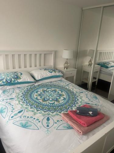 a bedroom with a bed with a blue and white comforter at Hidden beauty in peaceful place in Peterlee