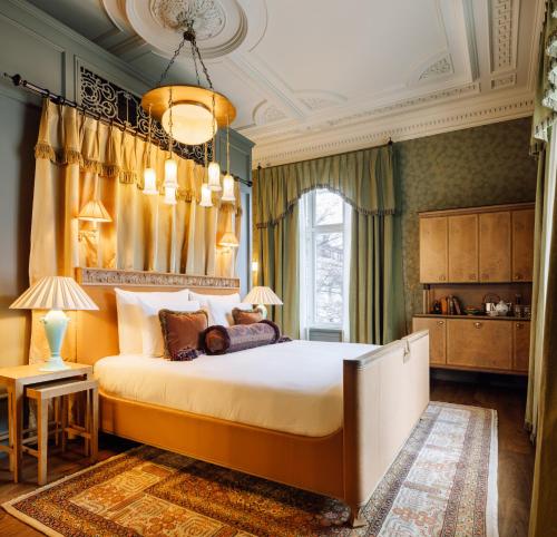 ein Schlafzimmer mit einem großen Bett und einem Kronleuchter in der Unterkunft Villa Inkognito by Sommerro in Oslo