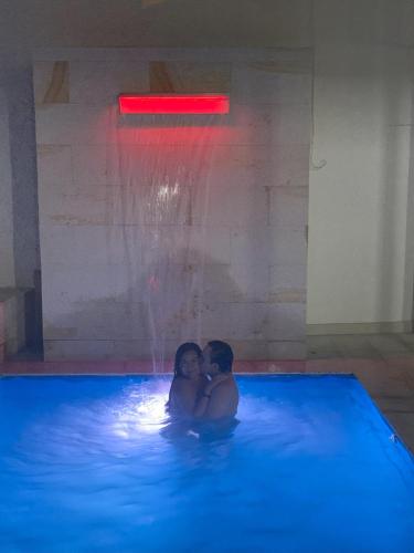 a man and woman in a swimming pool with a fountain at Hermosa Casa Central - Rositas's house in La Mesa