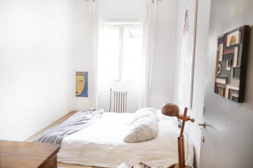 a small bedroom with a bed with white sheets at Roma Casal Palocco - Casa dell'artista in Casal Palocco