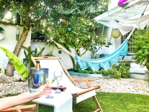 a person sitting on a chair with glasses of wine at Roma Casal Palocco - Casa dell'artista in Casal Palocco