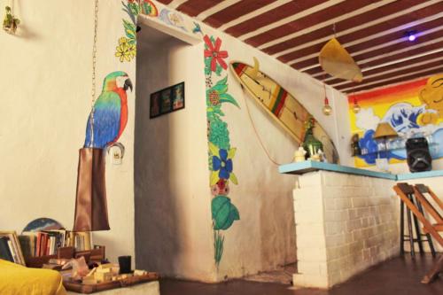 Raizes Surf and Bar Hostel في بوزيوس: غرفة بها باب مع لوحات على الحائط