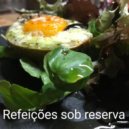 an egg on top of a salad with spinach at Quinta Padre Lobo in Santa Maria Da Feira