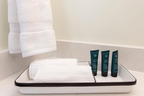 a tray with towels and toothbrushes on a bathroom counter at The Princess Anne 200 Inn at Old Beach in Virginia Beach
