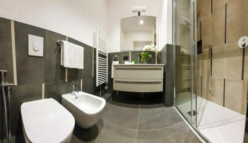 a bathroom with a white toilet and a sink at Emerald Green Residence in Caldiero